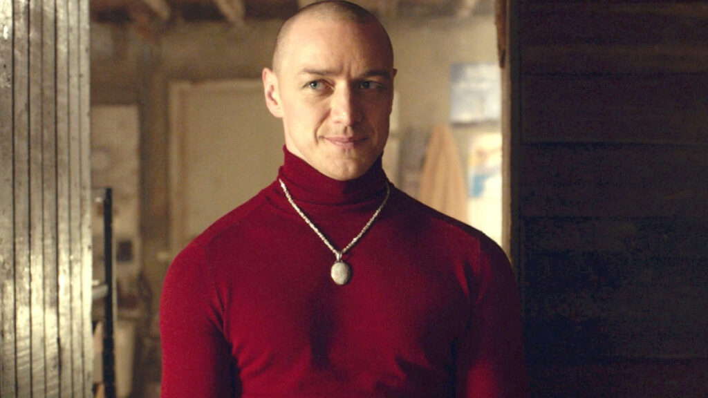 Kevin souriant avec un pull rouge
