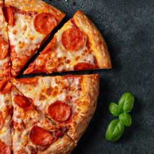 pizza découpée en part avec du basilic