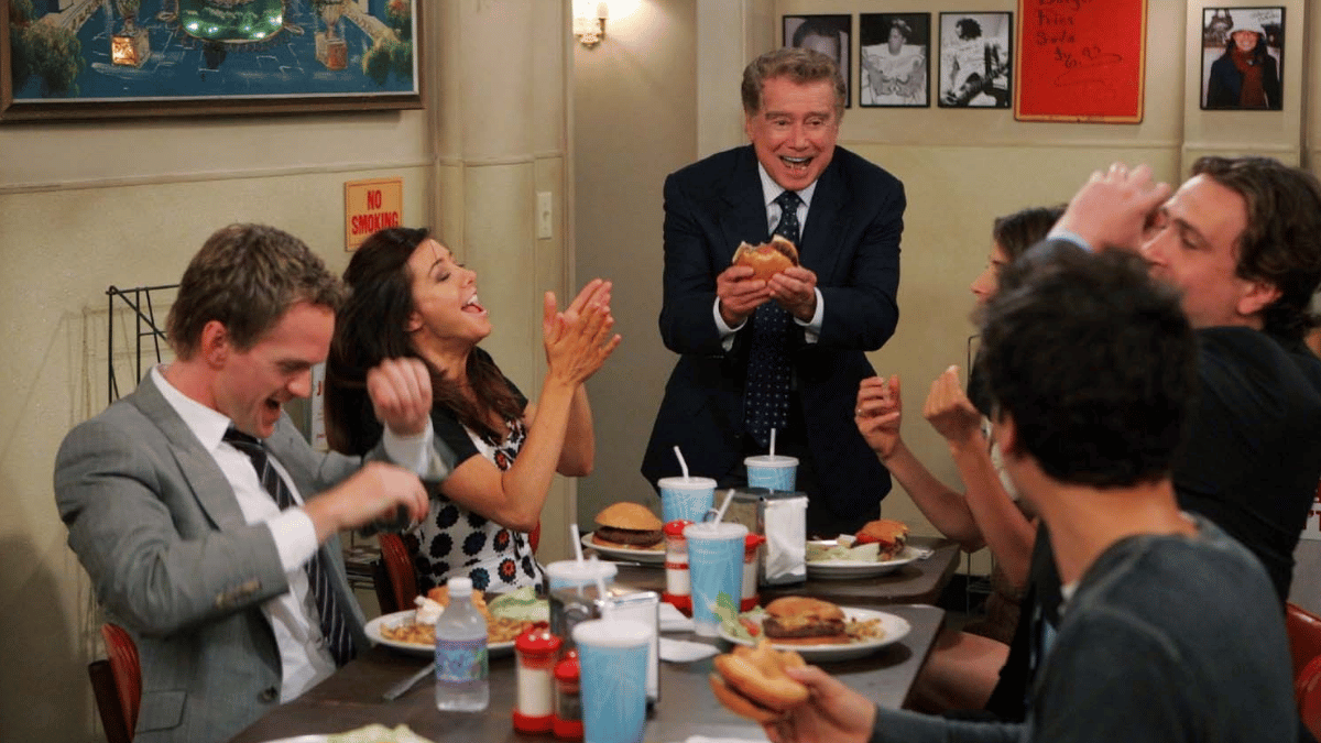 Barney, Lily, Marshall et Ted mangeant un hamburger avec Regis Philbin
